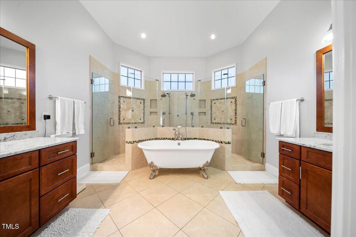 2304 Gresham Lake Road Raleigh, NC 27615 - Photo 30 of 55 a spacious bathroom with a bathtub shower sink and mirror