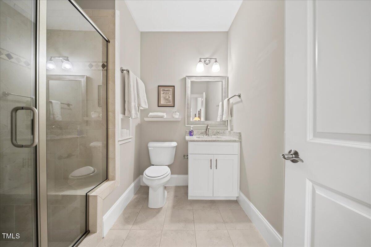 2304 Gresham Lake Road Raleigh, NC 27615 - Photo 39 of 55 a bathroom with a toilet sink a shower and a mirror