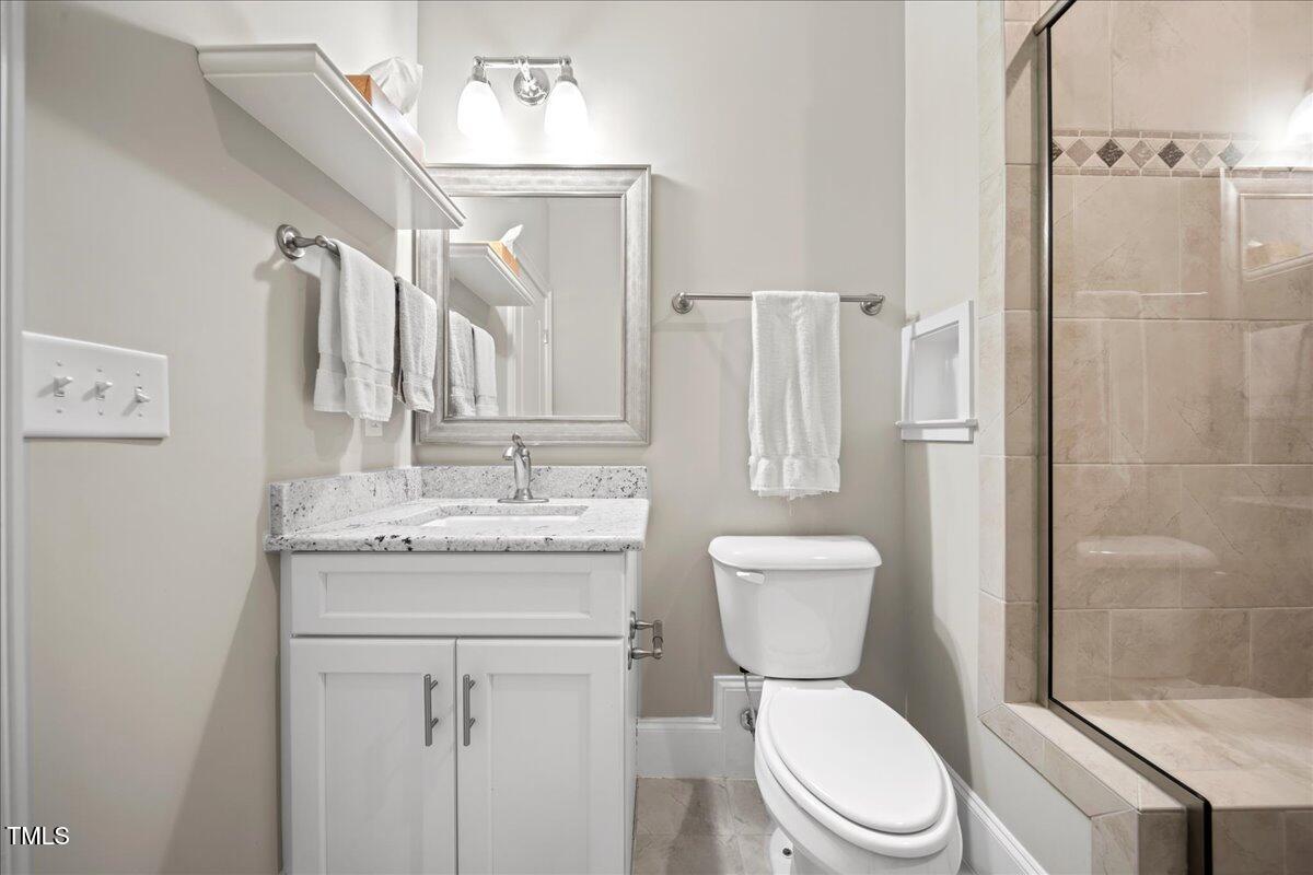 2304 Gresham Lake Road Raleigh, NC 27615 - Photo 47 of 55 a bathroom with a granite countertop toilet sink and a shower