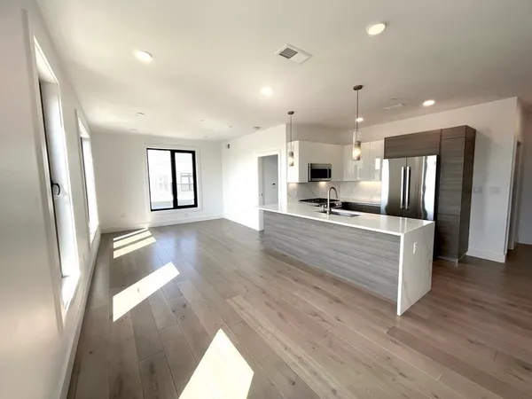 a kitchen with stainless steel appliances granite countertop a sink a window and chairs