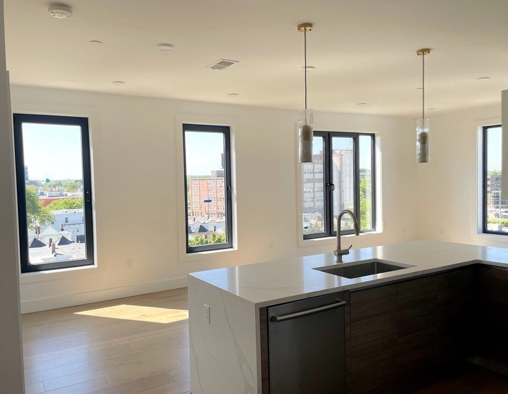 30 Penniman Road, Unit 507 Boston, MA 02134 - Photo 4 of 22 a kitchen with stainless steel appliances granite countertop a sink a window and chairs