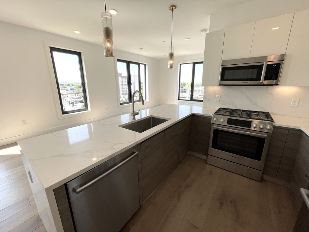 30 Penniman Road, Unit 507 Boston, MA 02134 - Photo 5 of 22 a kitchen with stainless steel appliances a sink stove and microwave