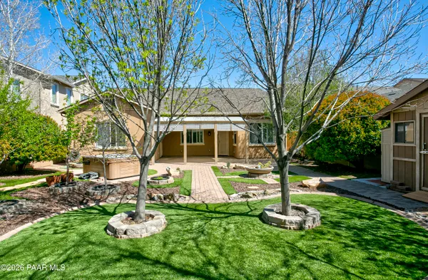 a front view of a house with a yard fire pit and large tree