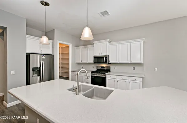 a kitchen with stainless steel appliances a stove refrigerator sink and microwave