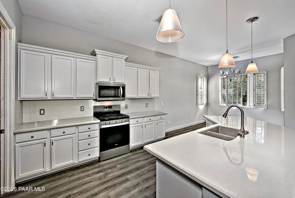 a kitchen with a sink a stove and cabinets