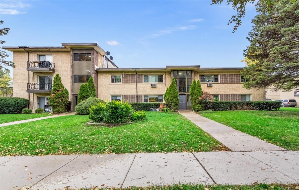 1080 North Wheeling Road, Unit 3B Mount Prospect, IL 60056 - Photo 1 of 8 front view of a house with a yard