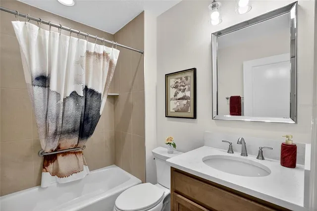 a bathroom with a granite countertop sink vanity mirror and toilet