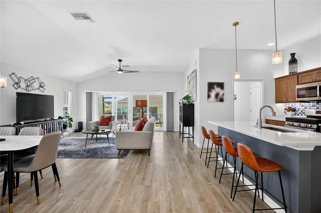 a living room with furniture a flat screen tv and kitchen view