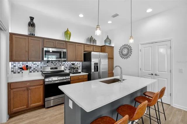 a kitchen with kitchen island a stove a sink a dining table and chairs