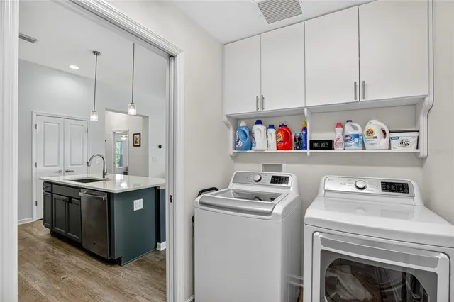 a utility room with sink dryer and washer