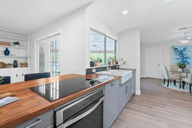 a kitchen with stainless steel appliances granite countertop a sink a counter space and dining table