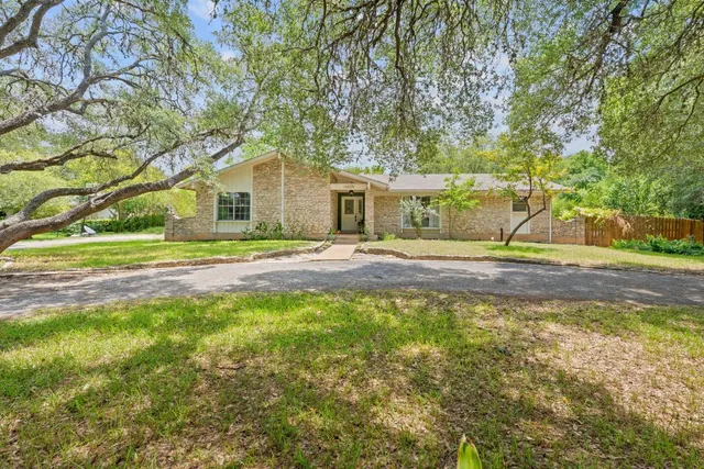 a front view of a house with a yard and trees