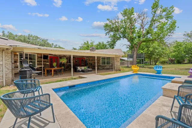 a view of a swimming pool with lawn chairs and couches