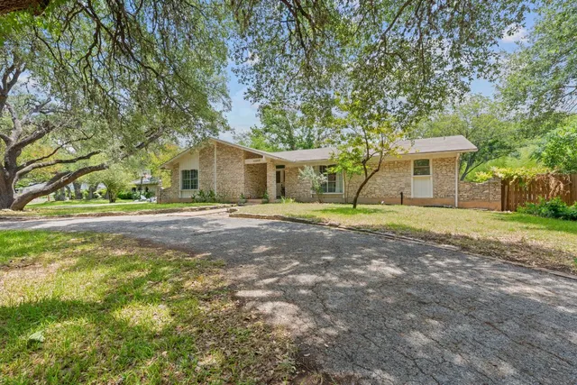 a front view of a house with a yard and trees