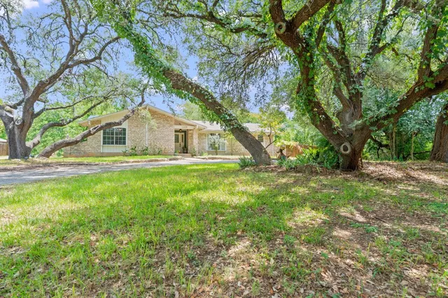 a view of house with backyard and trees