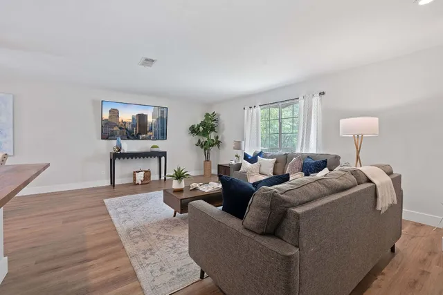a living room with furniture a large window and a flat screen tv