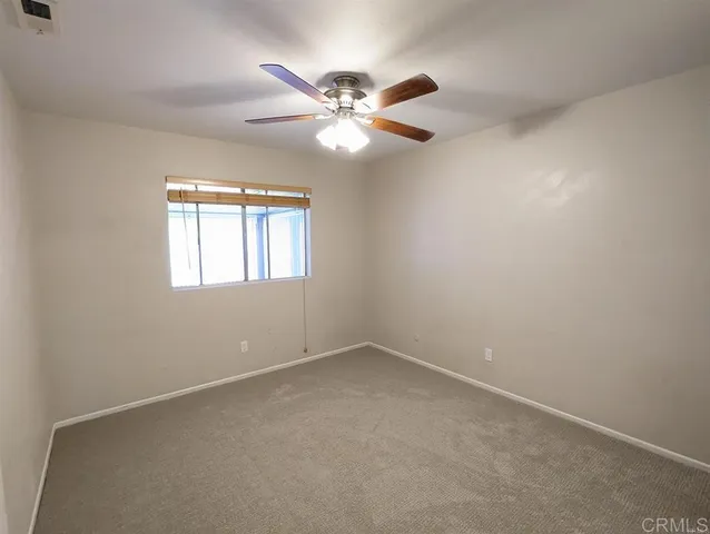 an empty room with window and fan