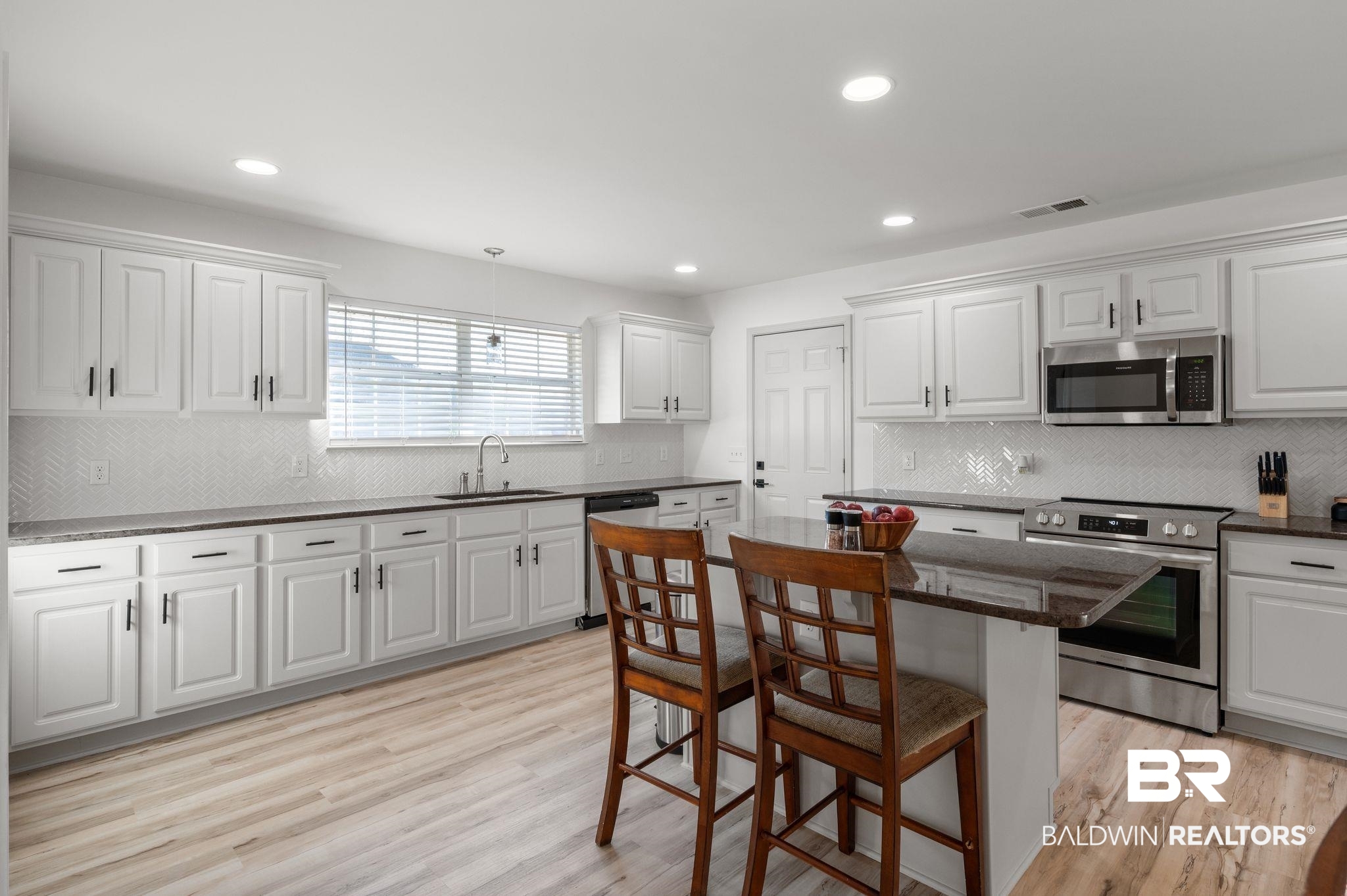 136 Destrehan Road Fairhope, AL 36532 - Photo 16 of 44 Kitchen with a center island, appliances with stainless steel finishes, light hardwood / wood-style flooring, and tasteful backsplash