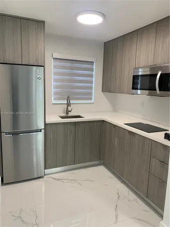 a kitchen with granite countertop a refrigerator and a sink