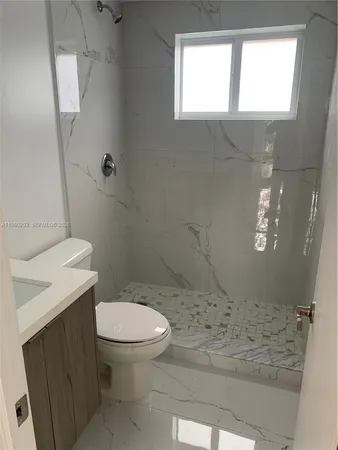a bathroom with a toilet and a shower