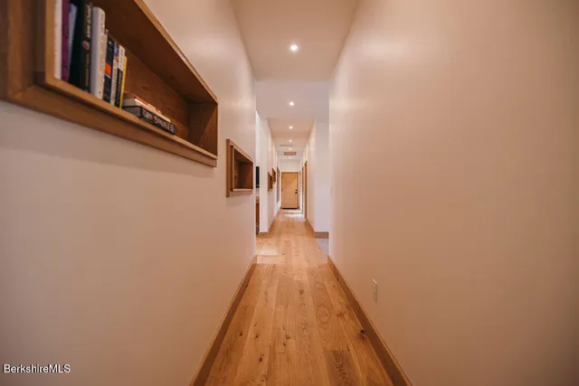 a view of a hallway with wooden floor and staircase