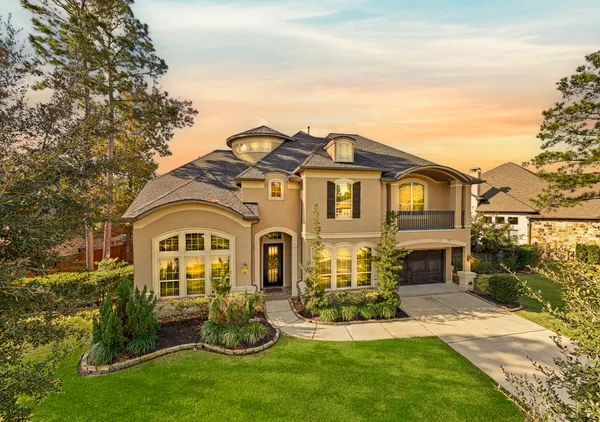 a front view of a house with a garden and plants