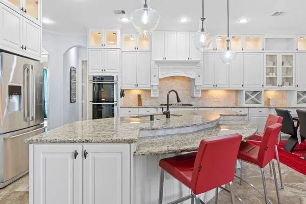 a kitchen with granite countertop a stove and a refrigerator