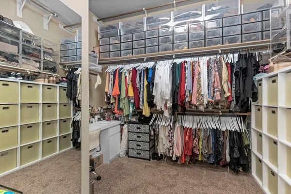 a view of walk in closet with clothes