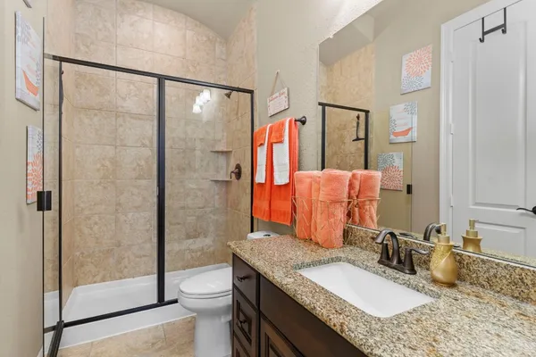a bathroom with a granite countertop sink toilet and shower