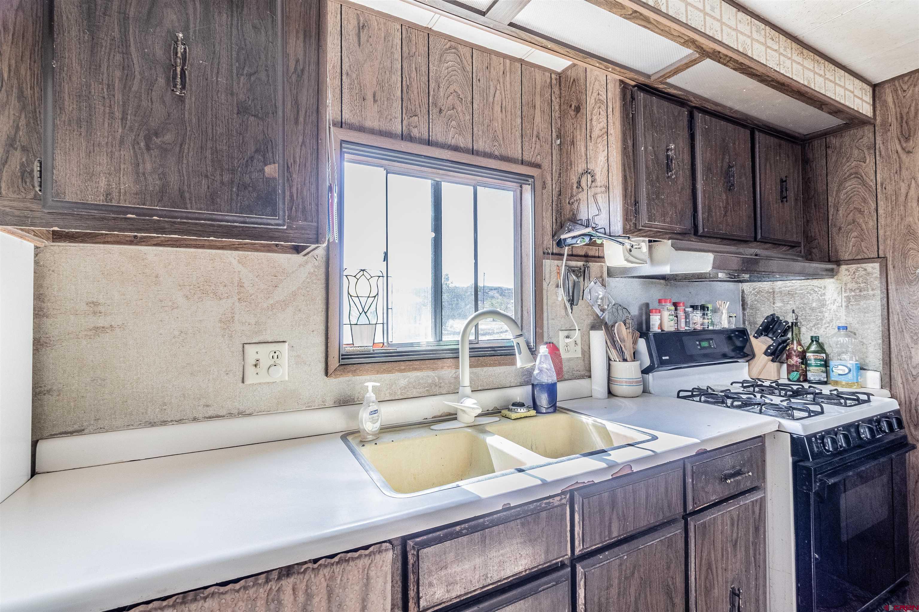 16923 Highway 550 Aztec, NM 87410 - Photo 11 of 45 a kitchen with a sink cabinets and a window