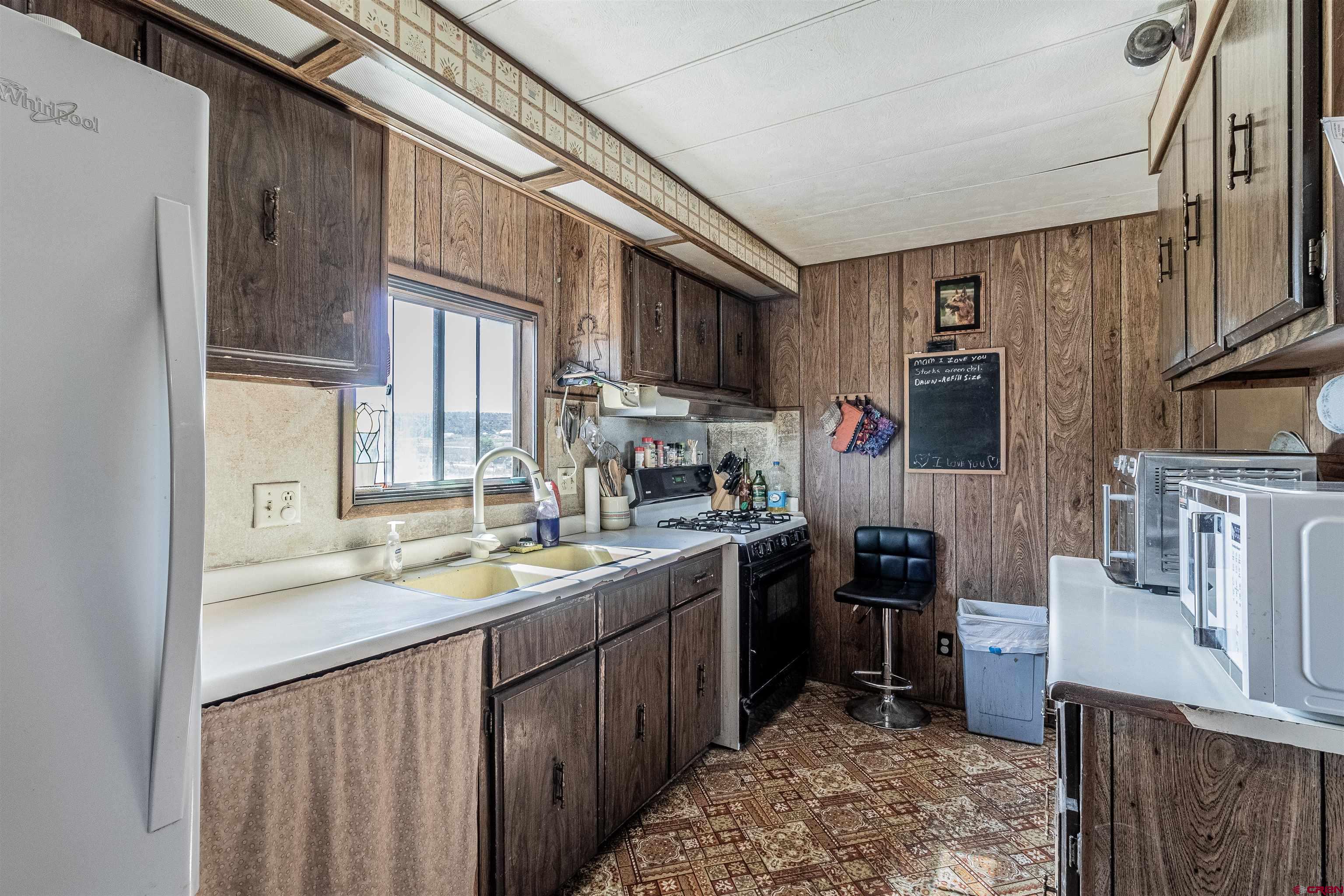 16923 Highway 550 Aztec, NM 87410 - Photo 12 of 45 a kitchen with stainless steel appliances granite countertop a sink stove and refrigerator