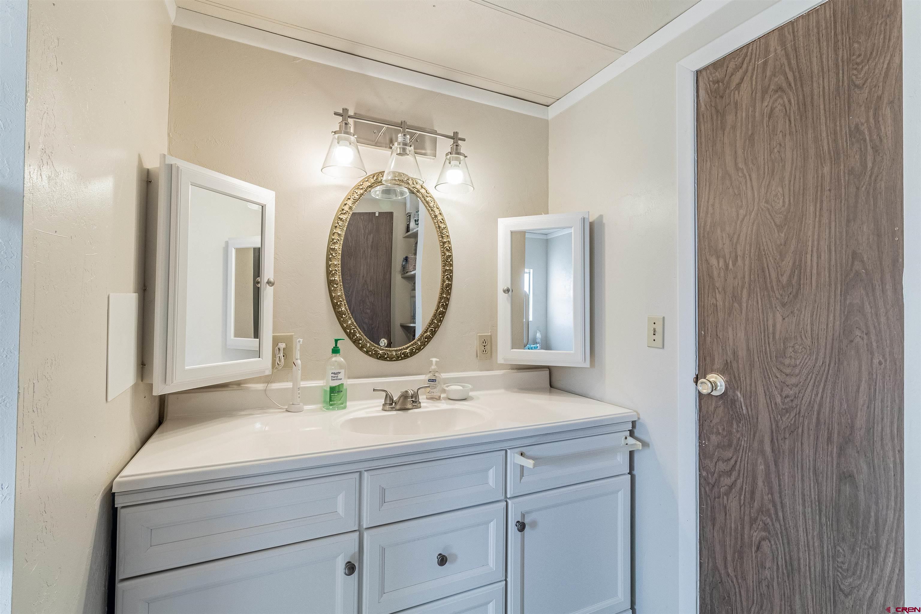 16923 Highway 550 Aztec, NM 87410 - Photo 17 of 45 a bathroom with a double vanity sink and a mirror