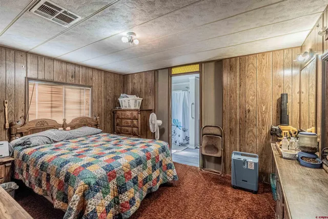 a bedroom with a bed and a dresser with mirror