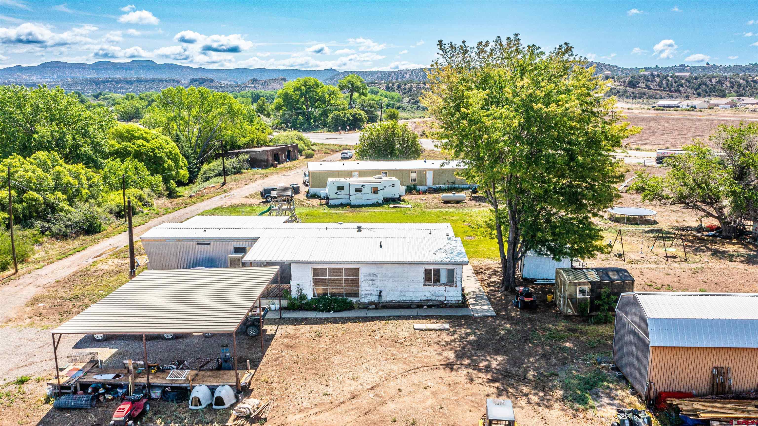 16923 Highway 550 Aztec, NM 87410 - Photo 2 of 45 a view of a house with a swimming pool lawn chairs and a barbeque
