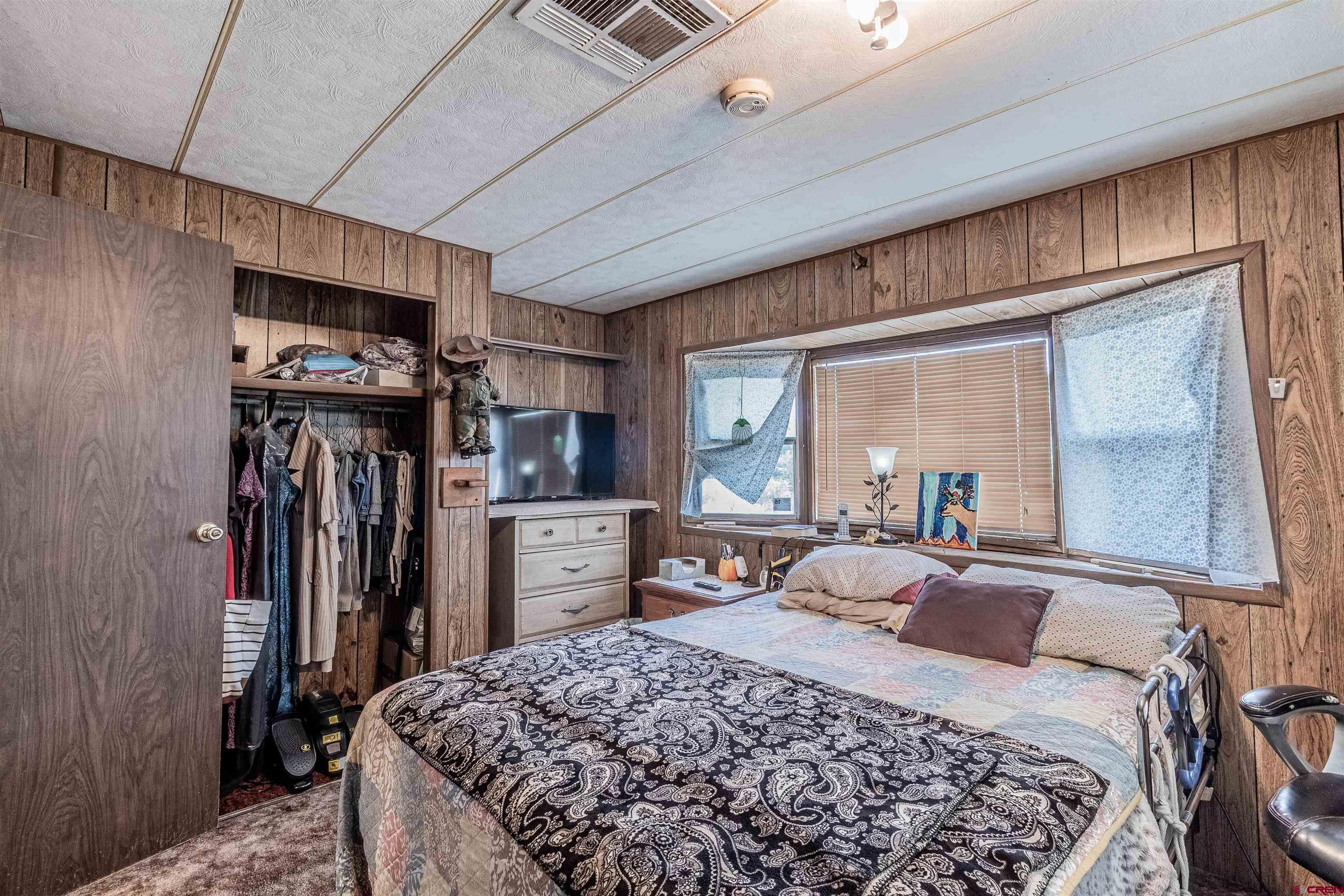 16923 Highway 550 Aztec, NM 87410 - Photo 21 of 45 a bedroom with a large bed and a dresser