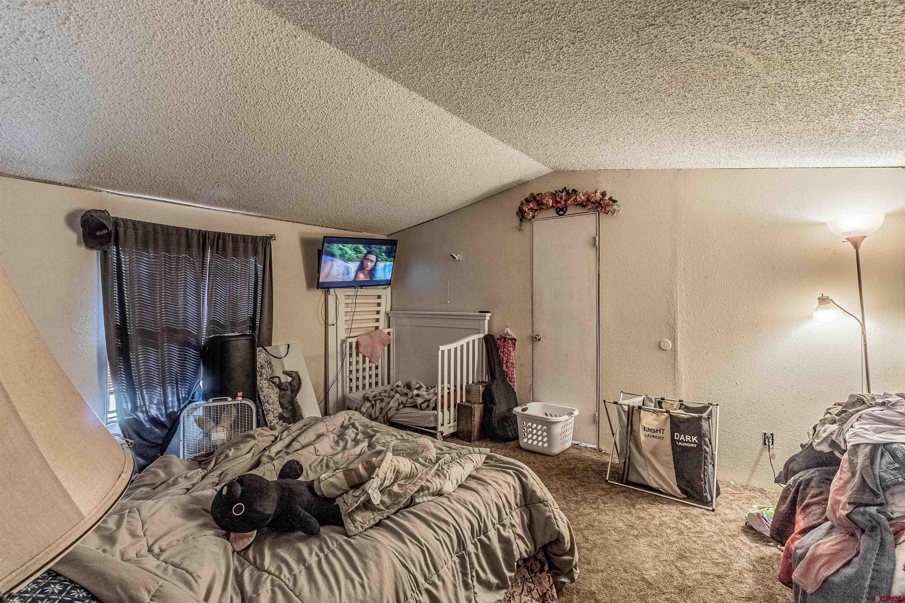 16923 Highway 550 Aztec, NM 87410 - Photo 37 of 45 a bedroom with a bed a desk and chair