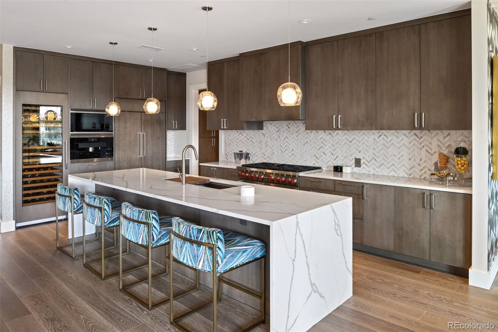 155 Steele Street, Unit 1117 Denver, CO 80206 - Photo 11 of 40 a kitchen with stainless steel appliances a sink a stove a table and chairs