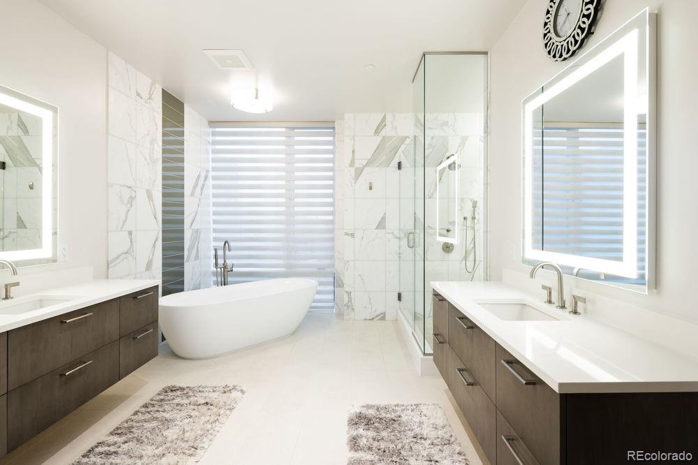 155 Steele Street, Unit 1117 Denver, CO 80206 - Photo 19 of 40 a spacious bathroom with a double vanity sink a mirror a bathtub and window