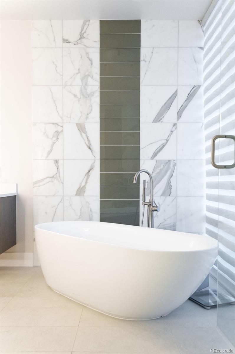 155 Steele Street, Unit 1117 Denver, CO 80206 - Photo 21 of 40 a white bath tub sitting in a bathroom