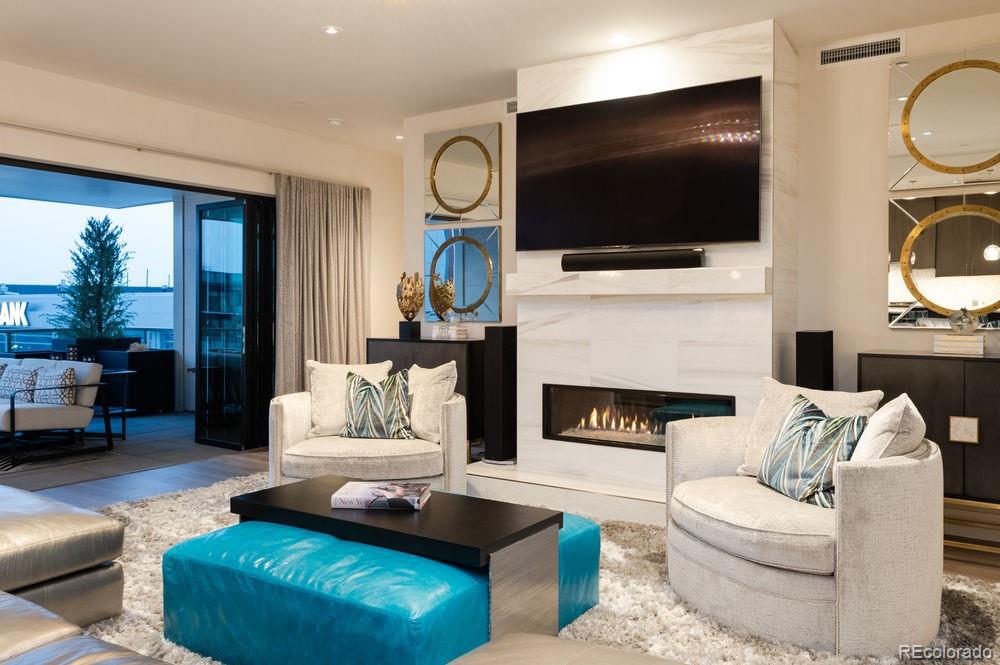 155 Steele Street, Unit 1117 Denver, CO 80206 - Photo 6 of 40 a living room with furniture a flat screen tv and a fireplace