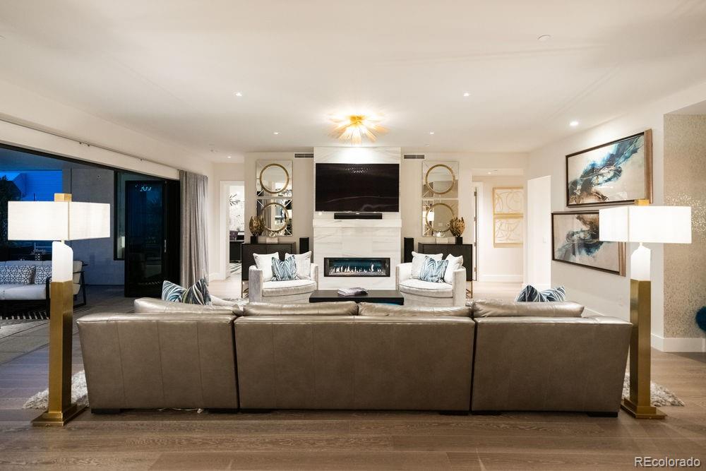 155 Steele Street, Unit 1117 Denver, CO 80206 - Photo 9 of 40 a living room with stainless steel appliances kitchen island granite countertop furniture a fireplace and a flat screen tv