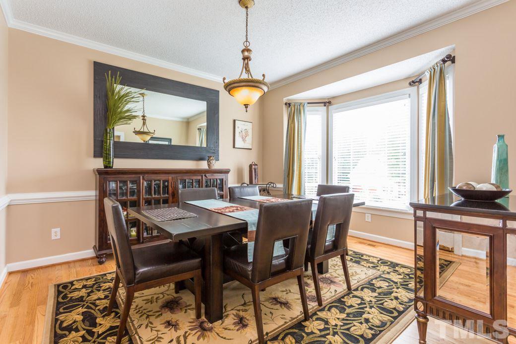 5220 Calverton Drive Raleigh, NC 27613 - Photo 3 of 25 a dining room with furniture a chandelier and wooden floor