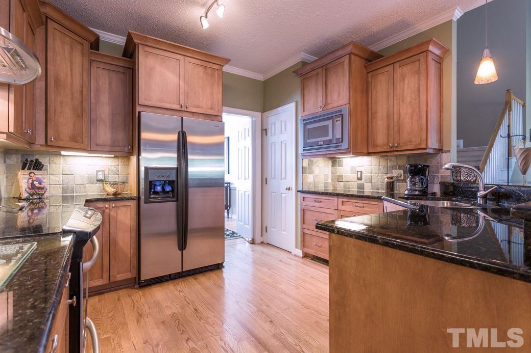 5220 Calverton Drive Raleigh, NC 27613 - Photo 8 of 25 a kitchen with stainless steel appliances granite countertop a refrigerator a sink and a stove