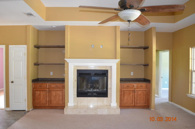 5965 Buckward Road Baker, FL 32531 - Photo 7 of 27 a living room with a fireplace and a chandelier