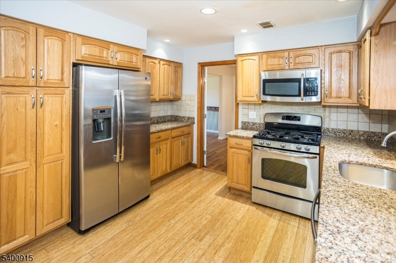 2 Bernard Court Lebanon, NJ 08833 - Photo 11 of 37 a kitchen with stainless steel appliances granite countertop a refrigerator a stove and a sink with wooden floor