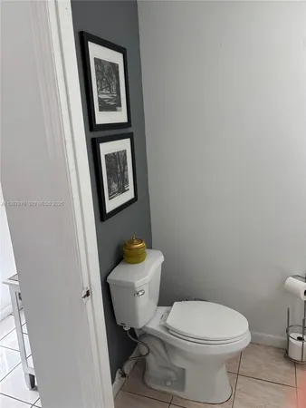 a white toilet sitting next to a white sink and vanity