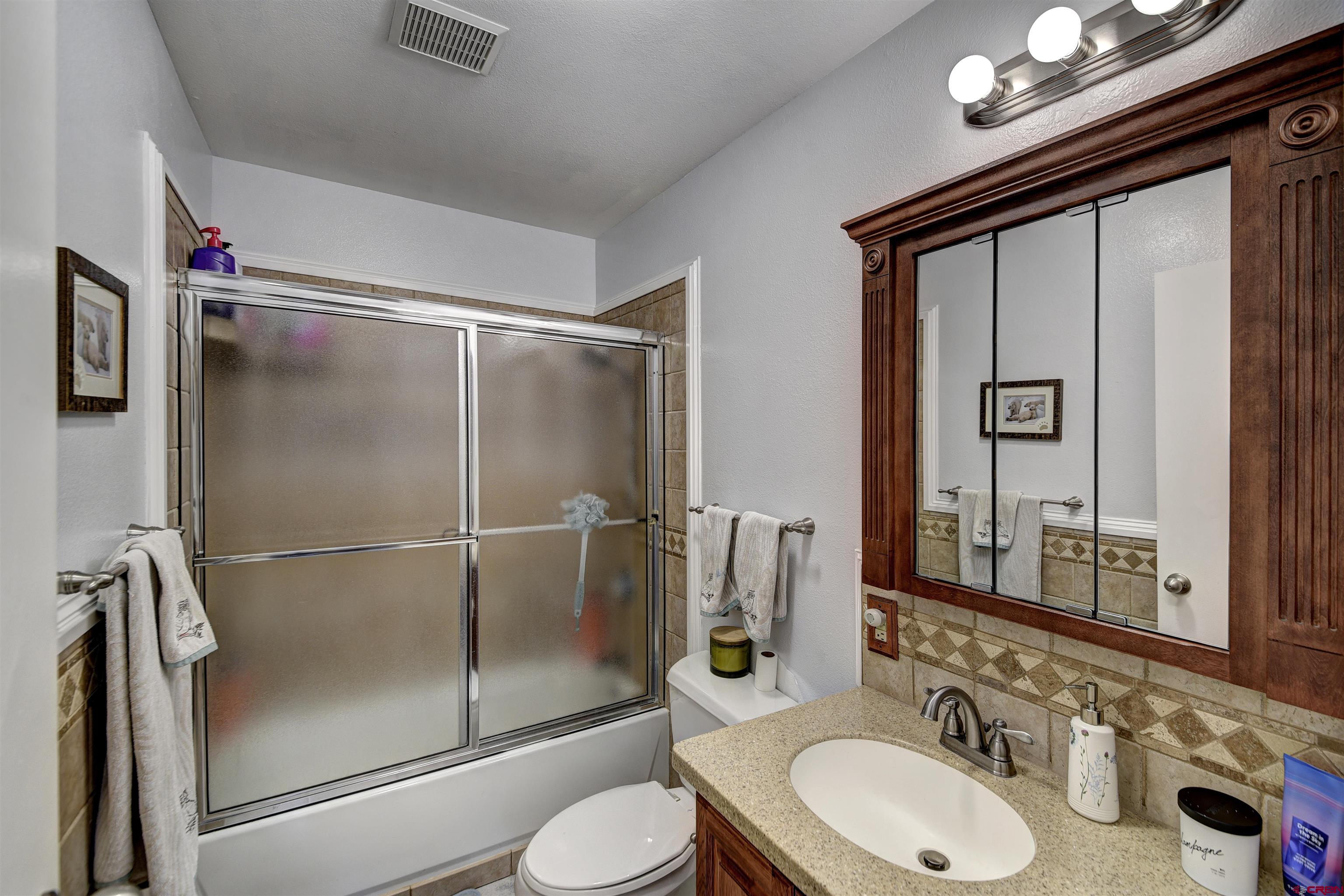 1172 Ridge Road Durango, CO 81303 - Photo 11 of 28 a bathroom with a shower sink vanity mirror and toilet