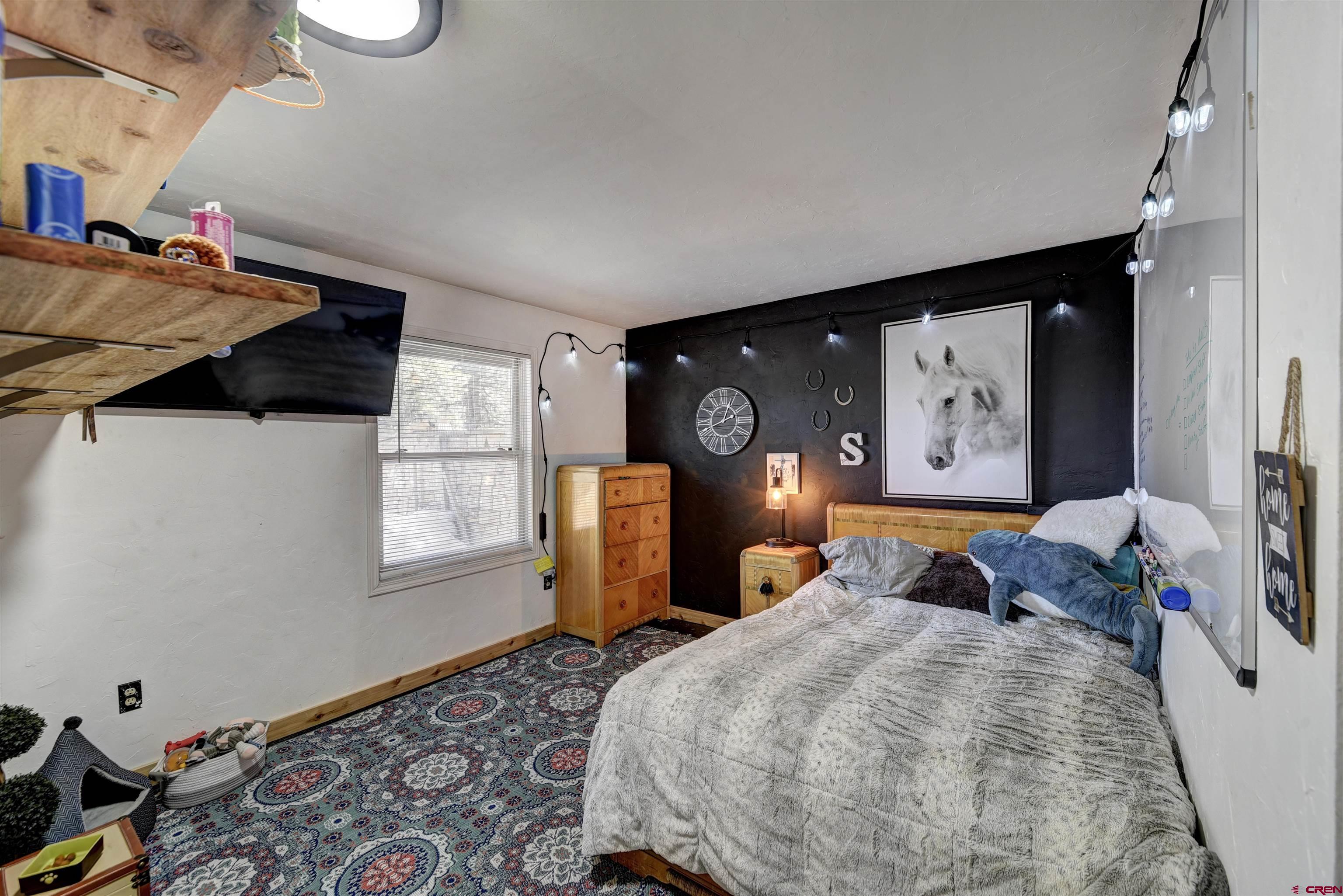 1172 Ridge Road Durango, CO 81303 - Photo 15 of 28 a bedroom with a bed and wooden floor