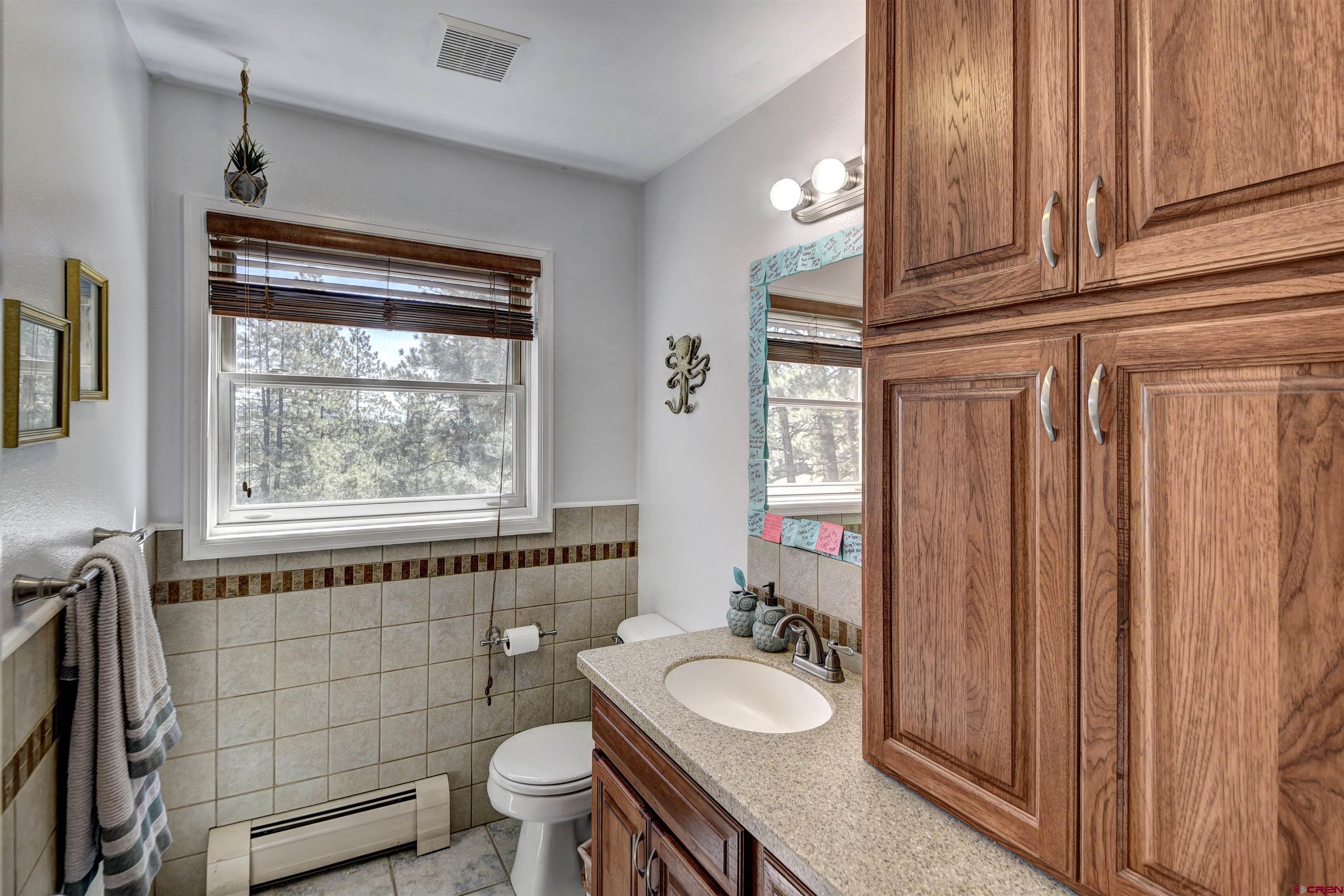 1172 Ridge Road Durango, CO 81303 - Photo 10 of 28 a bathroom with a granite countertop toilet a sink and a mirror