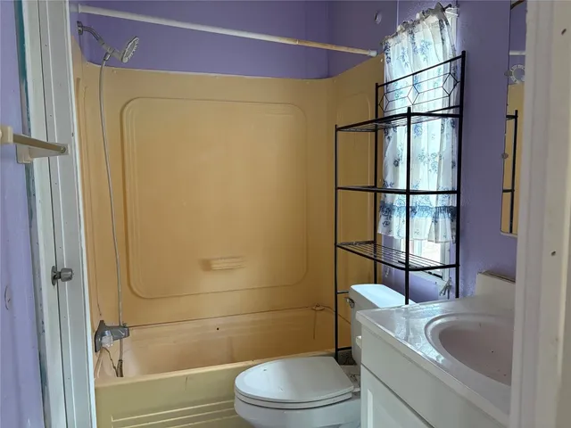 an empty room with a window and a ceiling fan